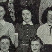 Rose Mangino, Joe’s sister, standing in the center of a black-and-white group photograph